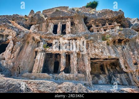 Antalya, Türkei - 18. Juli 2023: Die alten Felsengräber der antiken Stadt Tlos, aufwendig in den Hügel geschnitzt Stockfoto