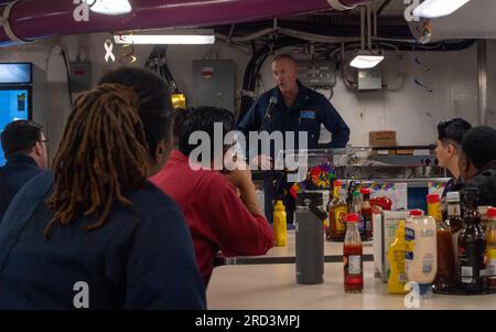 SAN DIEGO (28. JUNI 2023) – USA Navy Capt. Brian Schrum, kommandierender Offizier des Flugzeugträgers USS Theodore Roosevelt der Nimitz-Klasse (CVN 71), spricht anlässlich einer Festveranstaltung des Pride Month auf dem Schiffsdeck am 28. Juni 2023 vor der Besatzung. Theodore Roosevelt führt derzeit einen Materialbesuch durch, um die anstehende Überprüfung durch das Inspektions- und Besichtigungsamt (INSURV) zu unterstützen, eine vom Kongress beauftragte Bewertung des Bereitschaftszustands eines Schiffes, um sicherzustellen, dass alle Räume und Ausrüstungen den Marinestandards entsprechen. Stockfoto