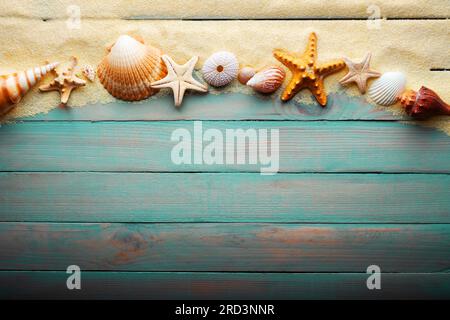 Vacations and summer time concept with starfish and sea shells on a turquoise wooden table with sand Stockfoto