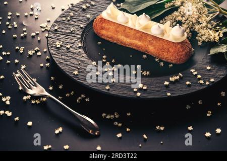 französischer eclair mit Schokolade oder süßen italienischen Profiteroles mit frischem kalten Zwerg-Ältestensaft, süßlich schmackhaft, Essen frisch im Sommer Hintergrund. Stockfoto