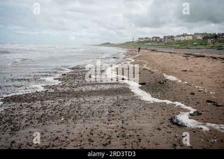 Leute, die am Strand in Seascale in der Nähe von Sellafield, Cumbria spazieren gehen Stockfoto