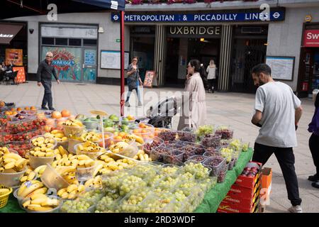 Zwei Tage vor der politischen Nachwahl kaufen die Bewohner Obst und Gemüse vor der U-Bahn-Station Uxbridge am 18. Juli 2023 in London, England. Der Wahlkreis Uxbridge und South Ruislip ist eine von drei lokalen Nachwahlen, die am selben Tag stattfinden, aber Uxbridge war im parlament acht Jahre lang durch den ehemaligen konservativen Premierminister Boris Johnson vertreten, bevor er als Abgeordneter zurücktrat. Am 20. Juli werden 17 Kandidaten dagegen antreten. Stockfoto