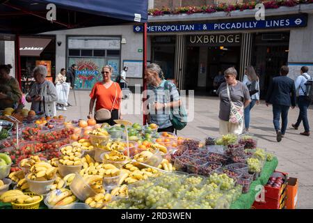 Zwei Tage vor der politischen Nachwahl kaufen die Bewohner Obst und Gemüse vor der U-Bahn-Station Uxbridge am 18. Juli 2023 in London, England. Der Wahlkreis Uxbridge und South Ruislip ist eine von drei lokalen Nachwahlen, die am selben Tag stattfinden, aber Uxbridge war im parlament acht Jahre lang durch den ehemaligen konservativen Premierminister Boris Johnson vertreten, bevor er als Abgeordneter zurücktrat. Am 20. Juli werden 17 Kandidaten dagegen antreten. Stockfoto