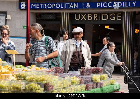 Zwei Tage vor der politischen Nachwahl kaufen die Bewohner Obst und Gemüse vor der U-Bahn-Station Uxbridge am 18. Juli 2023 in London, England. Der Wahlkreis Uxbridge und South Ruislip ist eine von drei lokalen Nachwahlen, die am selben Tag stattfinden, aber Uxbridge war im parlament acht Jahre lang durch den ehemaligen konservativen Premierminister Boris Johnson vertreten, bevor er als Abgeordneter zurücktrat. Am 20. Juli werden 17 Kandidaten dagegen antreten. Stockfoto