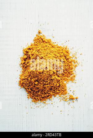 Haufen Garam Masala Gewürz auf weißem Holzhintergrund. Indische oder pakistanische Masala Puderhaufen, Draufsicht oder flache Lay Stockfoto