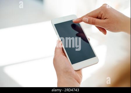 Sie war in der Geschäftswelt immer gut vernetzt. Freigestellte Aufnahme einer unbekannten Geschäftsfrau, die ihr Smartphone in einem Büro benutzt. Stockfoto