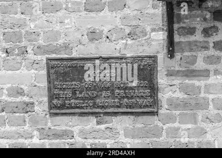 Eine alte Mauerpest aus den 1930er an einer Kneipenwand in Hampton Wick Stockfoto