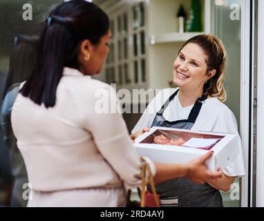 Ich hoffe, die versüßen Ihr Geschäftstreffen. Aufnahme eines Kunden, der ihre frisch gebackenen Cupcakes abholt. Stockfoto