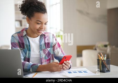 Teenager-Mädchen, die vom Lernen abgelenkt sind, telefonieren, gegen Gadget-sucht kämpfen. Stockfoto