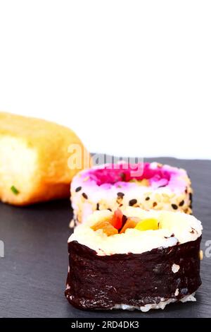 Vegane Sushi-Brötchen auf einer Servierplatte aus Schiefer Stockfoto