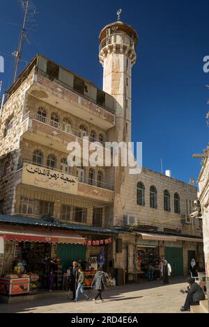 Muslimische Menschen passieren eine Moschee am Ende der Via Dolorosa in der Altstadt von Jerusalem Stockfoto