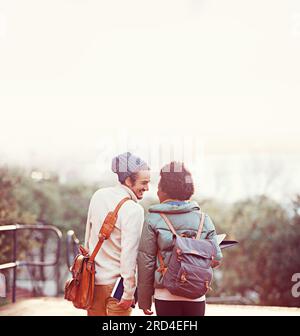 Junge Liebe. Rückblick auf ein liebevolles junges Paar auf dem Campus. Stockfoto