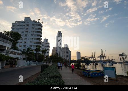 Cartagena, Bolivar, Kolumbien – 17. Februar 2023: Passanten machen einen Spaziergang an den Docks der Manga Island Marina mit mehreren kleinen Booten und der Skyline der Stadt Stockfoto