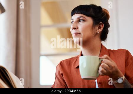 Ich kann mir keine bessere Möglichkeit vorstellen, das Wochenende zu verbringen. Foto einer attraktiven jungen Frau, die sich zu Hause entspannt. Stockfoto