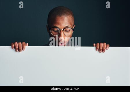 Oh, wirklich. Freigesetzte Aufnahme eines Mannes, der hinter einem leeren Plakat steht. Stockfoto