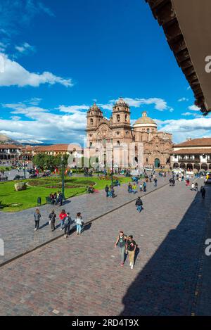 Leute auf dem Plaza de Armas Hauptplatz von Cusco mit der Jesuitengesellschaft von Jesus Kirche, Peru. Stockfoto