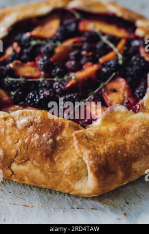 Pfirsich, Brombeere, Thymian-Galette, Nahaufnahme auf Pergamentpapier direkt aus dem Ofen Stockfoto