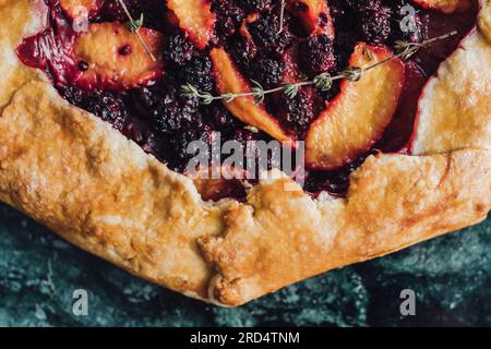 BlackBerry, Pfirsich, Thymian-Galette auf grünem Marmorbrett Stockfoto