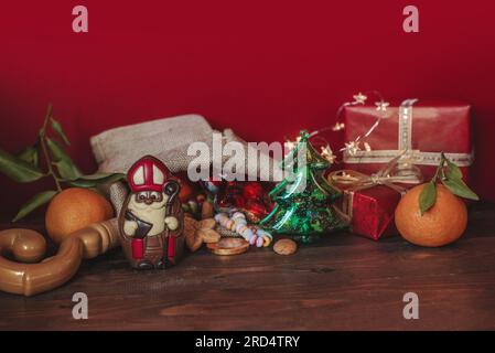 Weihnachtsgeschichte St. Nikolaus, Sinterklaas, Schokolade, Kekse, Nüsse, Mandarinen, Geschenke und Süßigkeiten Stockfoto