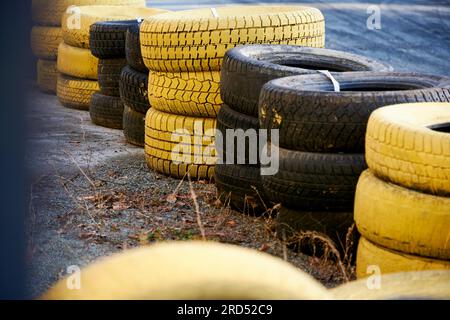 Schwarz-gelber Reifenstapel für Zäune auf Rennstrecken Stockfoto