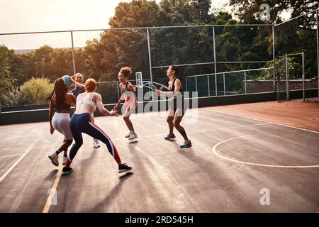 Ich versuche, durchzukommen. Kurze Aufnahme einer vielfältigen Gruppe von Sportlerinnen, die tagsüber gemeinsam ein Wettkampfspiel spielen. Stockfoto