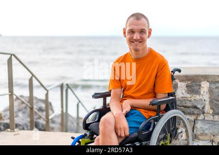 Porträt einer behinderten Person im Rollstuhl am Strand im Sommerurlaub Stockfoto