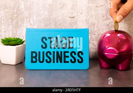 Geschäfts- und Finanzkonzept. Auf rotem Hintergrund, Zahnrädern und einer Denktafel mit der Aufschrift "STAGE Business" Stockfoto