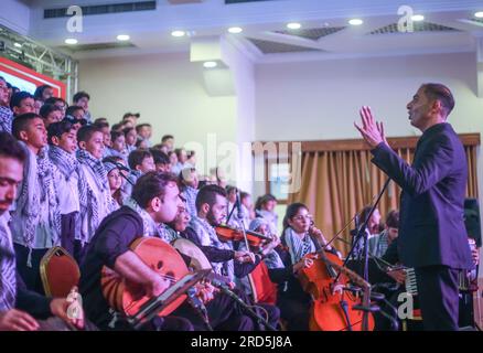 Gaza, Palästina. 18. Juli 2023. Ein palästinensischer Maestro nimmt an einer Abschlusszeremonie für den Kinderchor mit dem Titel „Enjoy your life with music“ in Gaza-Stadt Teil. Eine musikalische Gruppe der Al-Sununu Foundation for Culture veranstaltet in Zusammenarbeit mit der Deutschen Agentur eine Abschlusszeremonie für den Kinderchor mit dem Titel "Enjoy your life with music". In Anwesenheit des palästinensischen Ministers für Frauenangelegenheiten, Amal Hamad, des Generaldirektors der UNRWA-Operationen in Palästina, Thomas White, und Dutzender an Musik interessierter Palästinenser. Kredit: SOPA Images Limited/Alamy Live News Stockfoto