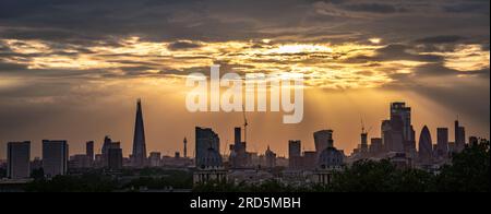 London, Großbritannien. 18. Juli 2023 UK Weather: Dramatische Sonnenuntergänge über der Stadt, die von der Spitze des Greenwich Park aus gesehen werden, beenden einen weiteren warmen Sommertag (mehrere Bilder, Panorama-Verschmelzung). Kredit: Guy Corbishley/Alamy Live News Stockfoto