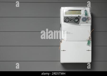 Stromzähler an grauer Holzwand, Platz für Text Stockfoto