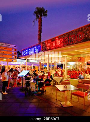 Lanzarote Canary Islands Bars, Geschäfte und Restaurants an der Ave Las Playas mit klarem dunkelblauem Abendhimmel Stockfoto