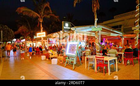 Lanzarote Canary Islands Bars, Geschäfte und Restaurants an der Ave Las Playas mit klarem dunkelblauem Abendhimmel Stockfoto