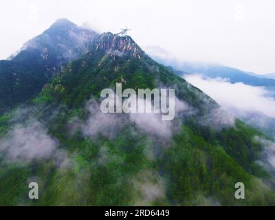 ANQING, CHINA - 19. JULI 2023 - Luftfoto zeigt die Phoenix Love Glass Aussichtsplattform der Feiqizhai Scenic Area, umgeben von Wolken in Yuexi coun Stockfoto