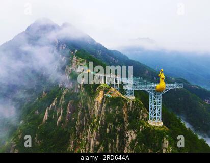 ANQING, CHINA - 19. JULI 2023 - Luftfoto zeigt die Phoenix Love Glass Aussichtsplattform der Feiqizhai Scenic Area, umgeben von Wolken in Yuexi coun Stockfoto