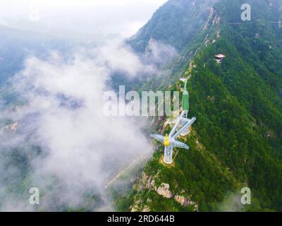 ANQING, CHINA - 19. JULI 2023 - Luftfoto zeigt die Phoenix Love Glass Aussichtsplattform der Feiqizhai Scenic Area, umgeben von Wolken in Yuexi coun Stockfoto