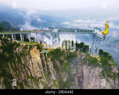 ANQING, CHINA - 19. JULI 2023 - Luftfoto zeigt die Phoenix Love Glass Aussichtsplattform der Feiqizhai Scenic Area, umgeben von Wolken in Yuexi coun Stockfoto