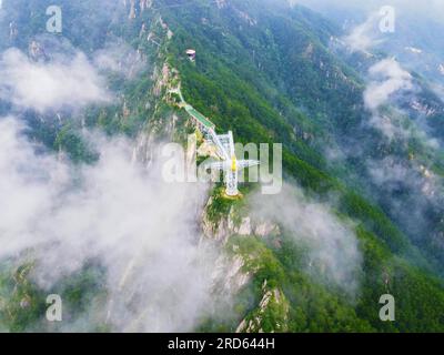 ANQING, CHINA - 19. JULI 2023 - Luftfoto zeigt die Phoenix Love Glass Aussichtsplattform der Feiqizhai Scenic Area, umgeben von Wolken in Yuexi coun Stockfoto