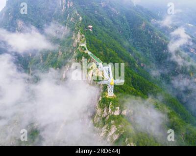 ANQING, CHINA - 19. JULI 2023 - Luftfoto zeigt die Phoenix Love Glass Aussichtsplattform der Feiqizhai Scenic Area, umgeben von Wolken in Yuexi coun Stockfoto