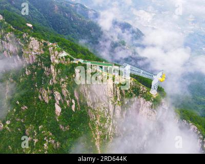 ANQING, CHINA - 19. JULI 2023 - Luftfoto zeigt die Phoenix Love Glass Aussichtsplattform der Feiqizhai Scenic Area, umgeben von Wolken in Yuexi coun Stockfoto