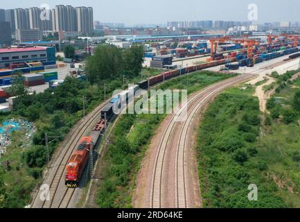 Zhengzhou, Deutschland verlässt den Bahnhof Putian in Zhengzhou. 18. Juli 2013. Dieses Luftfoto wurde am 18. Juli 2023 aufgenommen und zeigt einen Güterzug zwischen China und Europa nach Hamburg, der den Bahnhof Putian in Zhengzhou, der Hauptstadt der zentralchinesischen Provinz Henan, verlässt. Zhengzhou hat seit dem 18. Juli 2013 7.572 Güterzüge zwischen China und Europa abgefertigt, die 670.000 TEU (20 Fuß äquivalente Einheiten) beförderten. Kredit: Li Jianan/Xinhua/Alamy Live News Stockfoto