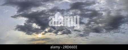 Dramatisch bewölkter Dämmerlichthimmel bei Sonnenuntergang. Sommerabend. Panoramabild. Stockfoto