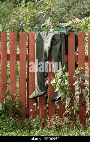 Taucheranzug trocknet auf Holzzaun im Garten Stockfoto