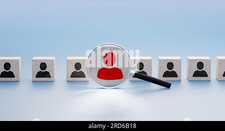 Auswahlkonzept. Der Personalmanager wählt eine neue Person aus, die einer Organisation oder einem Support-Fall beitreten soll. Vergrößerungsglas zoomt Würfel mit bester Person. Stockfoto