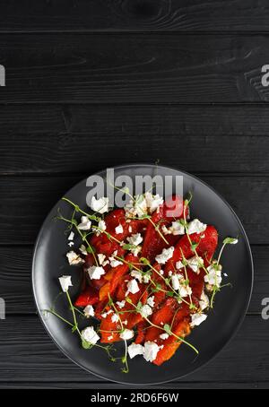 Gebratene rote Paprika auf einem Teller mit Fetakäse, Draufsicht, vertikales Banner Stockfoto