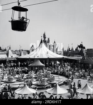 Die Mad Tea Party Teetasse Fahrt in Disneyland ist umgeben von großen Menschenmassen mit der originalen Skyliner Aerial Tram. Stockfoto