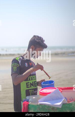 Er verkauft Snacks an cox's Basar Beach Stockfoto