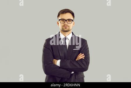 Studioporträt eines seriösen jungen Geschäftsmanns in klassischem Anzug, Hemd, Krawatte und Brille Stockfoto