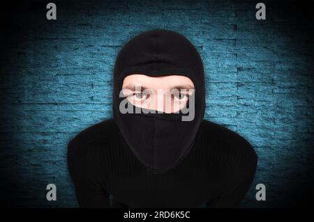 Räuber in Maske auf einem blauen Wand-Hintergrund Stockfoto