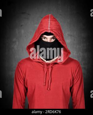 Terrorist mit roter Kapuze und Maske auf weißem Hintergrund Stockfoto