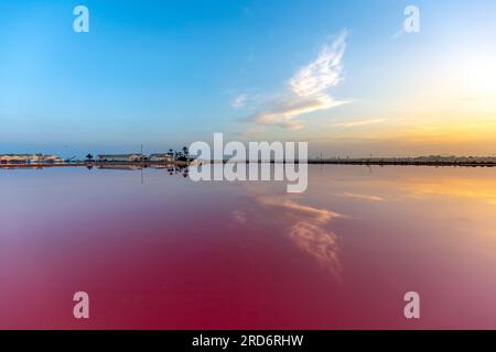 Panoramablick auf die Salinas de San Pedro del Pinatar, Murcia, Spanien, mit Reflexion des Himmels auf der rosafarbenen Salzpfanne und dem blauen Himmel Stockfoto